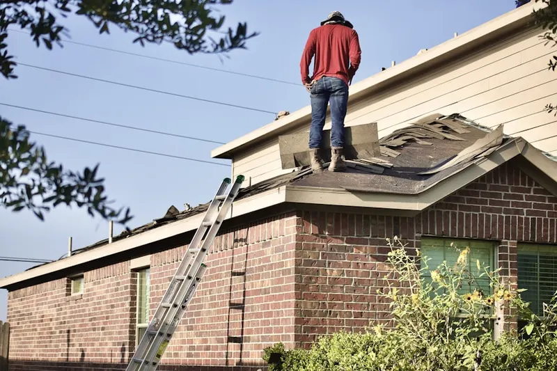 Professional roofer working on a residential roof in Ash